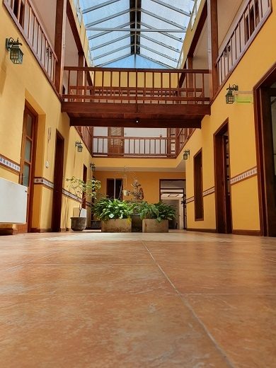 Galería de madera del primer piso sobre el patio, bajo una claraboya