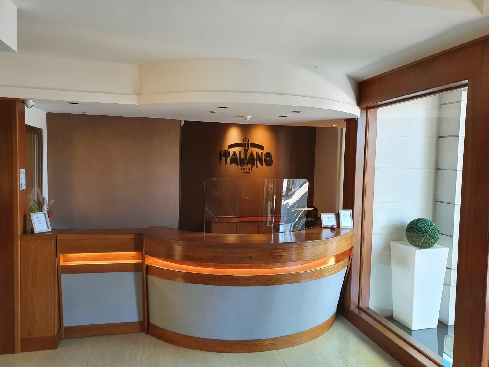 Mostrador de recepción de madera con el logo del hotel