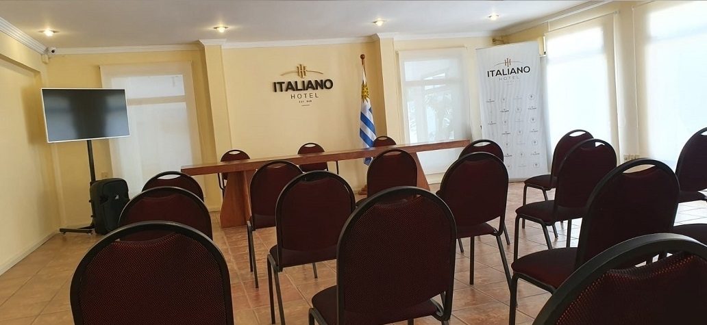 Sala de conferencias armada en auditorio, con sillas tapizadas y pantalla